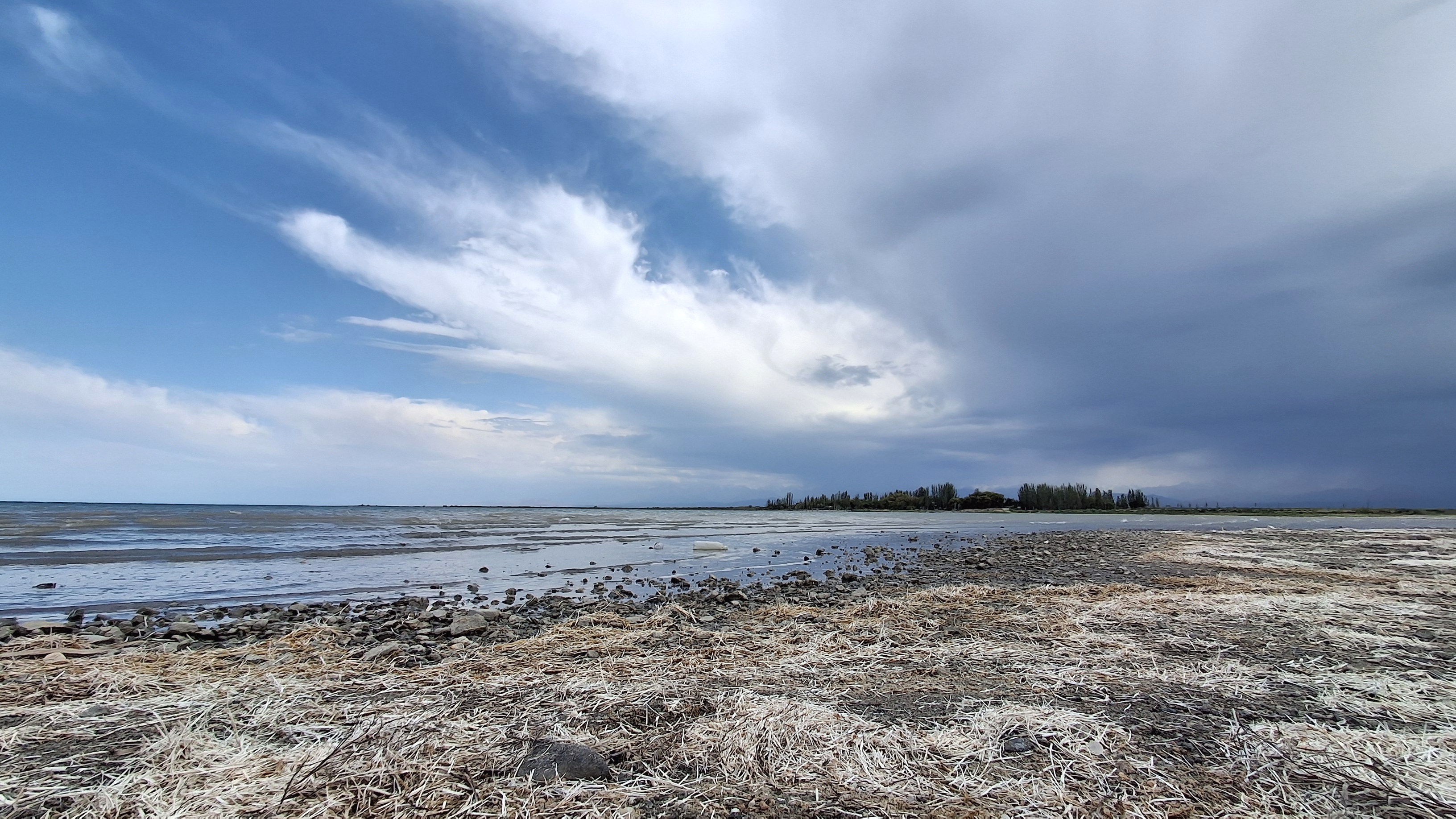 Panoramic view of Issyk-Kul lake with snow-capped Tien Shan mountains in background