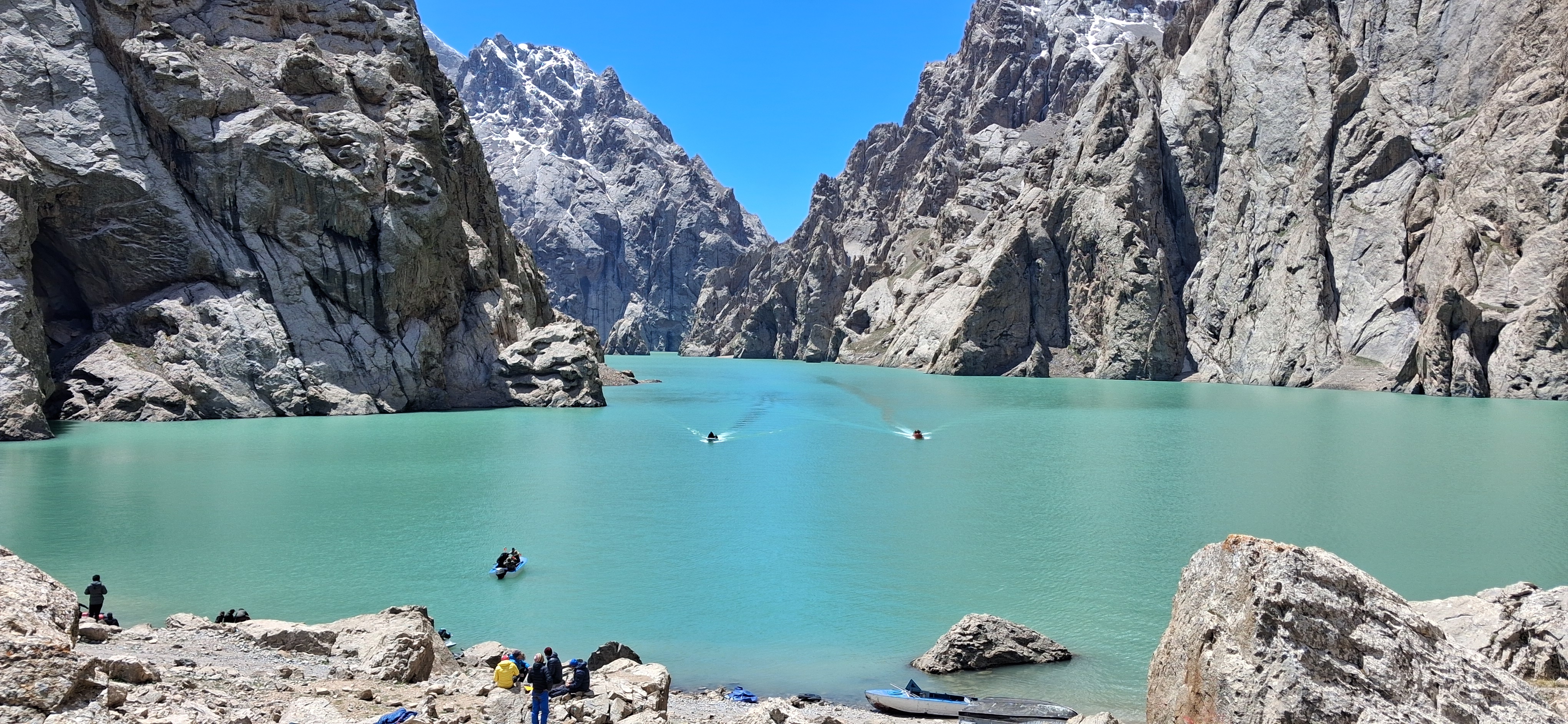 Remote Kol-Suu lake with dramatic red canyon walls reflected in still water