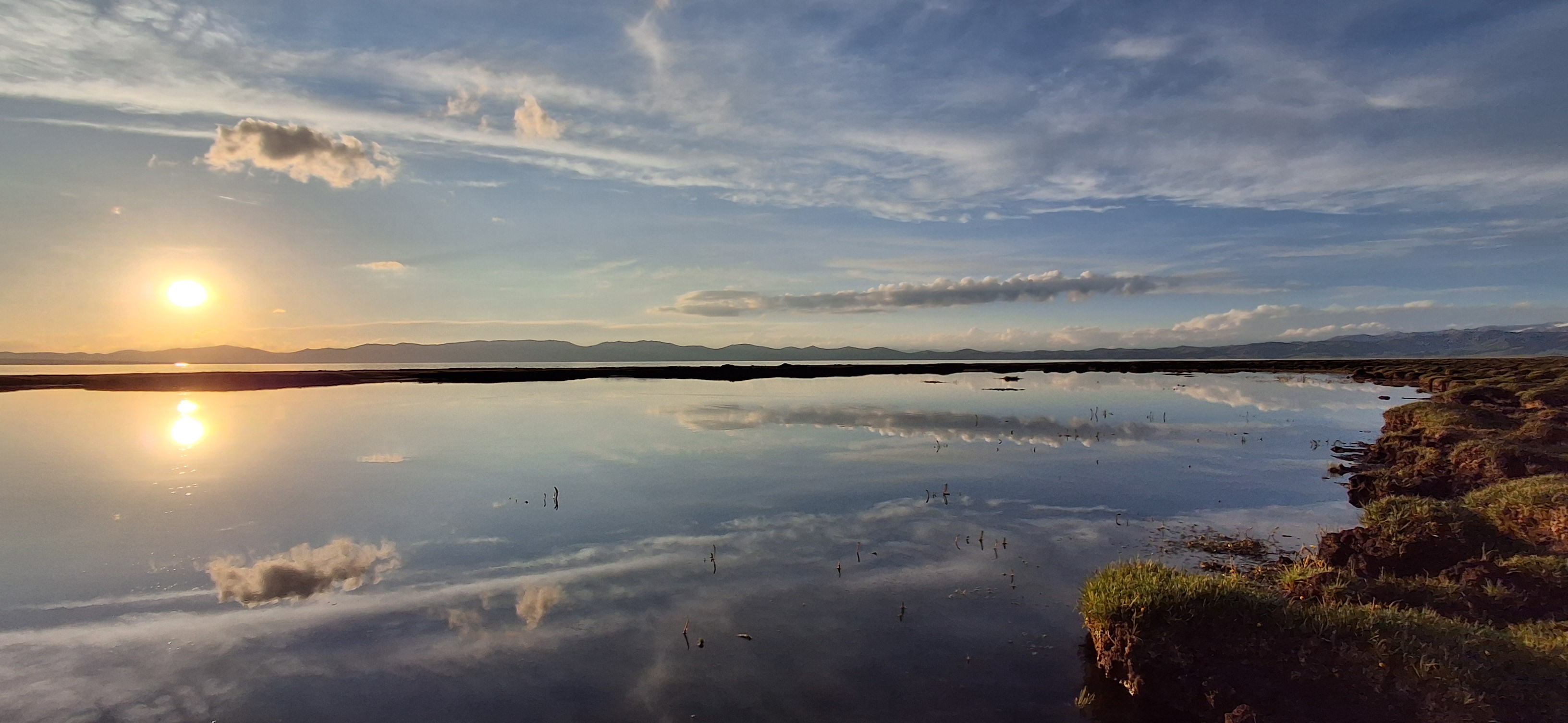 Song-Kul alpine lake at sunset with yurts and horses on the plateau